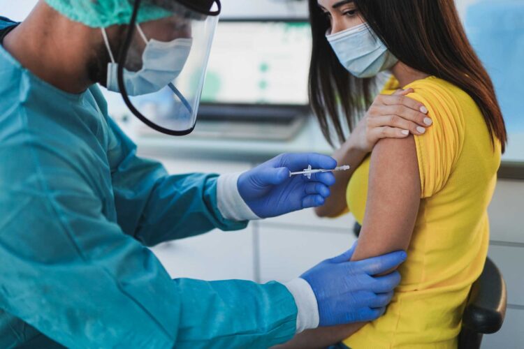 male-doctor-vaccine-a-young-woman-patient-shoulder